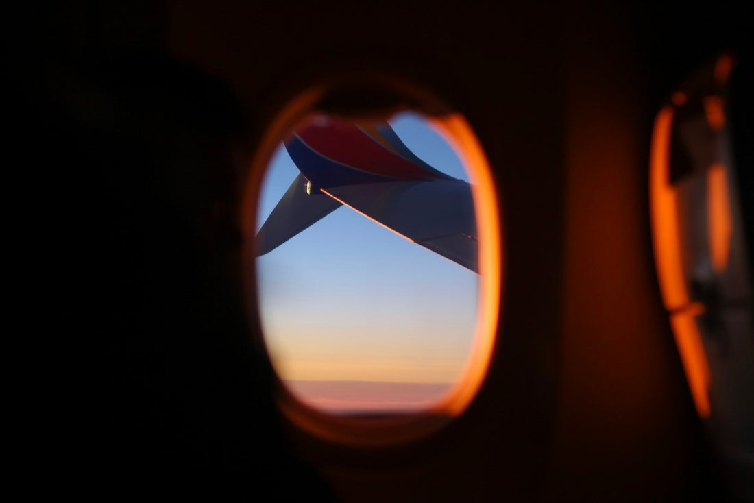 Sunrise light through an airplane window above the clouds on an early morning flight