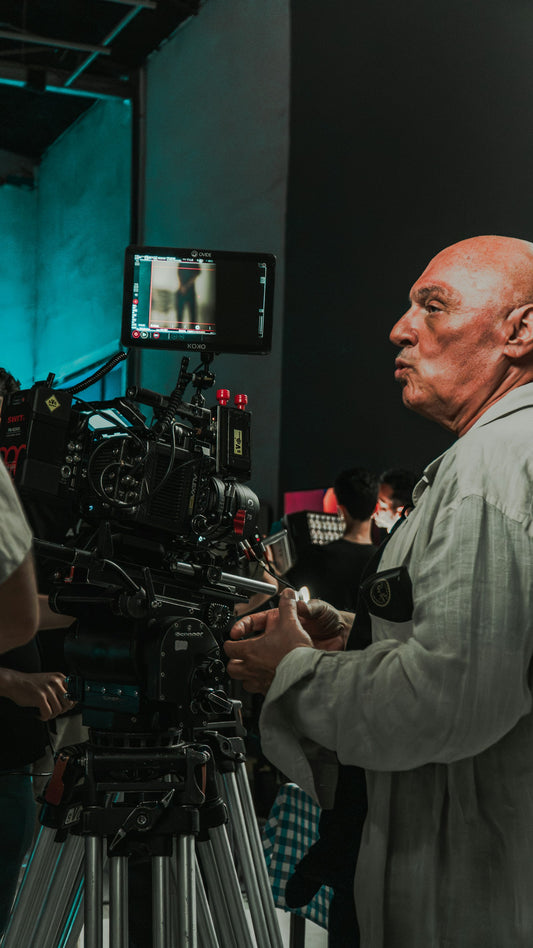 Film crew member working beside a professional cinema camera on a production set